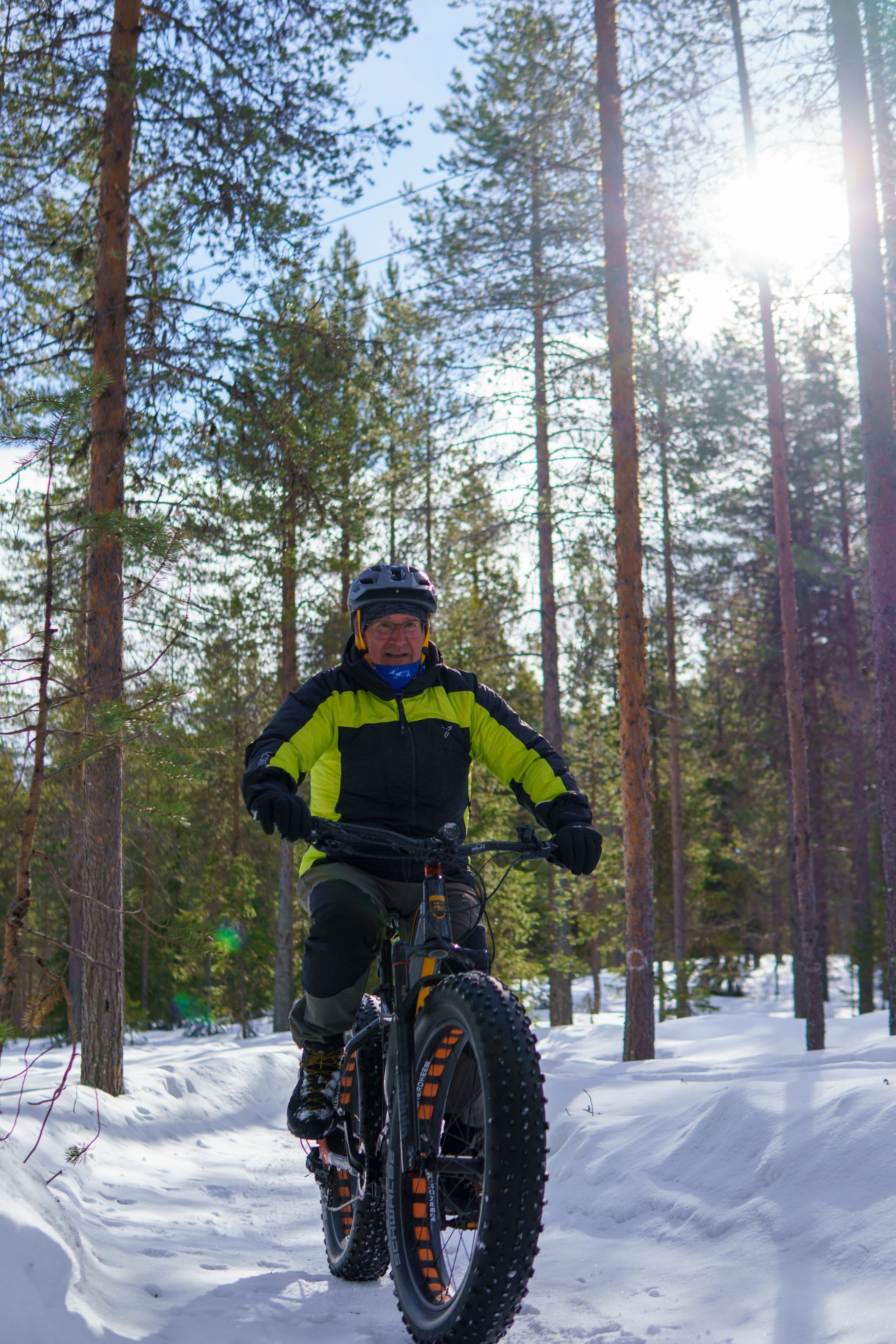 Sähköläskipyöräilijä lumisella metsäpolulla